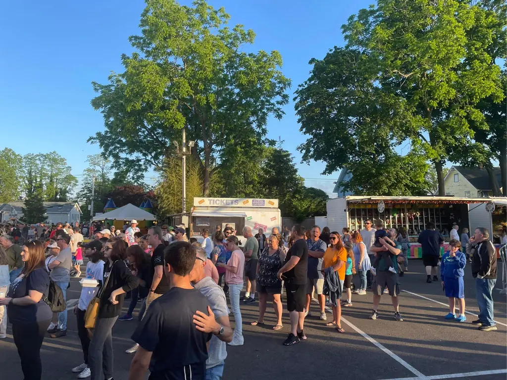 Festival-goers filling the grounds on a summer evening